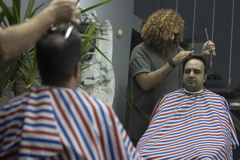 Kapster merapikan rambut pelanggan